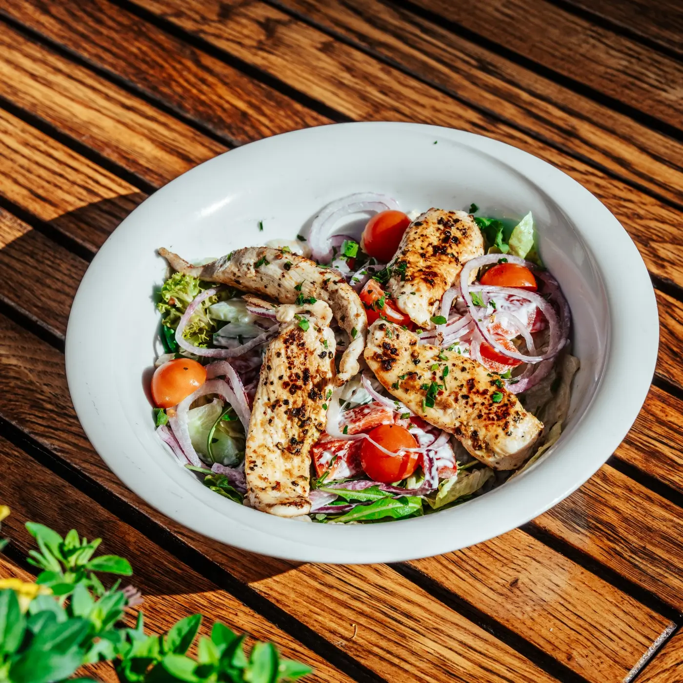 Hühnerstreifen auf knackigem Blattsalat im Schanigarten Plutzer Bräu